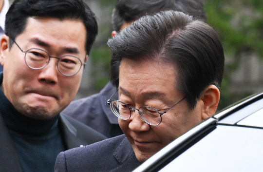 지난 11월25일 더불어민주당 이재명 대표가 25일 오후 서울 서초구 서울중앙지법에서 열린 '위증교사' 혐의 사건 1심 선고 공판에서 무죄선고를 받은 뒤, 차에 타기 전 의원들에게 인사를 하고 있다. 왼쪽은 박찬대 원내대표.<사진공동취재단·연합뉴스>